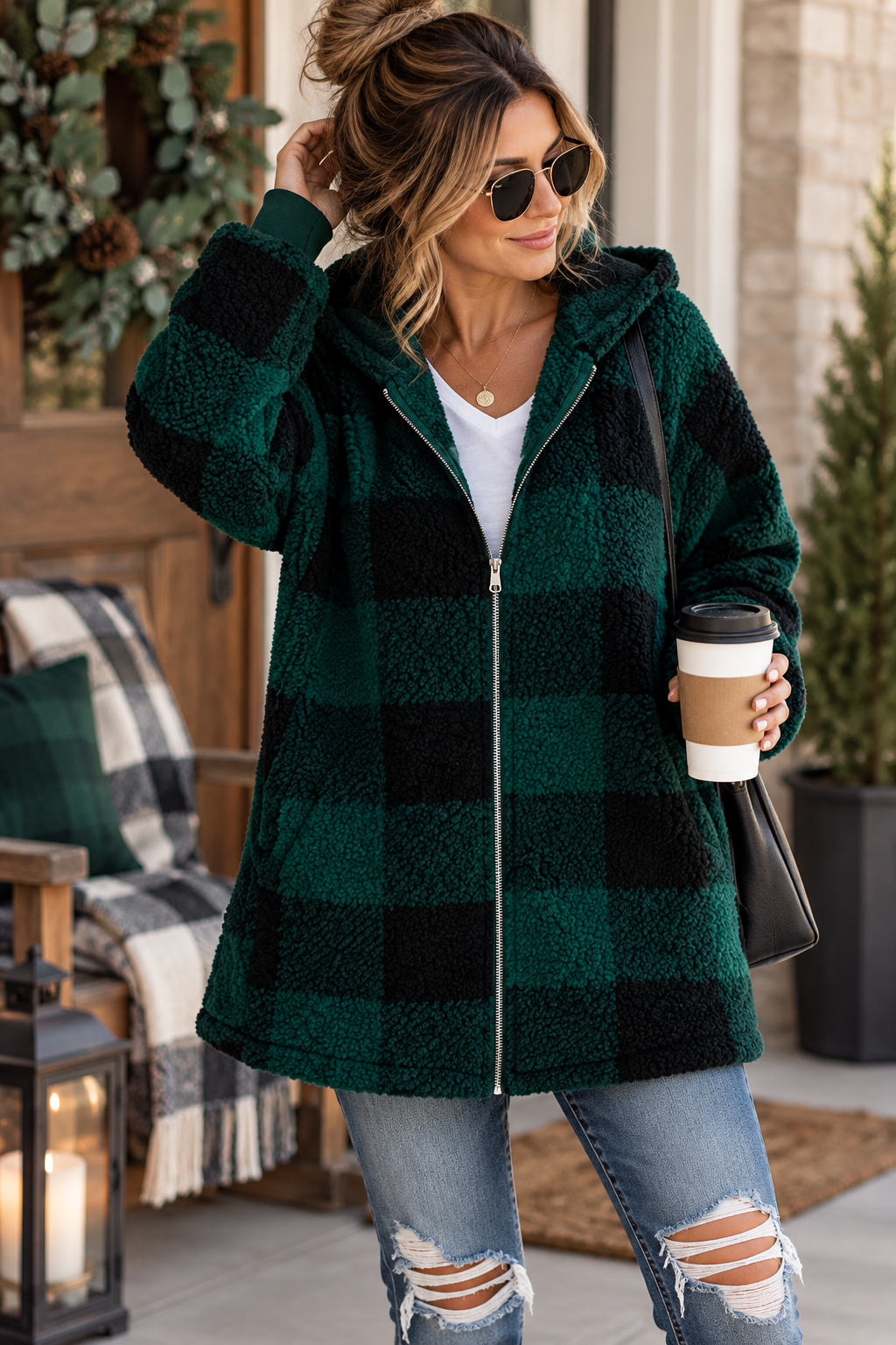 ChalkboardxChaos woman wearing a deep green and black buffalo plaid sherpa hooded zip-up jacket with jeans