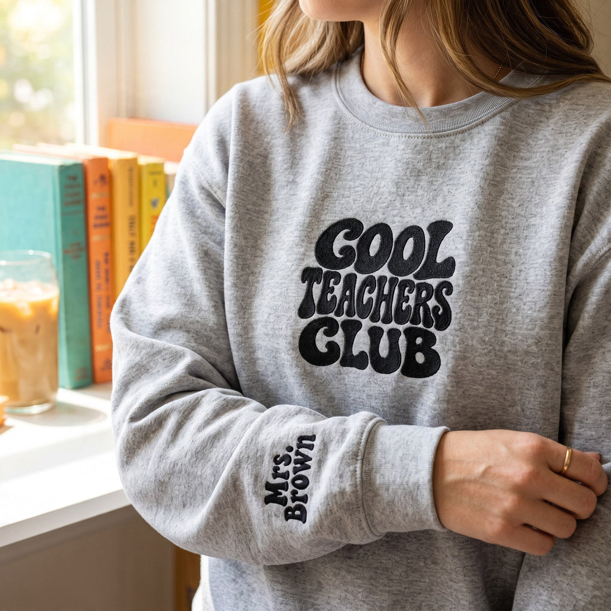 ChalkboardxChaos grey sweatshirt with Cool Teachers Club retro bubble lettering and personalized name on the wrist.