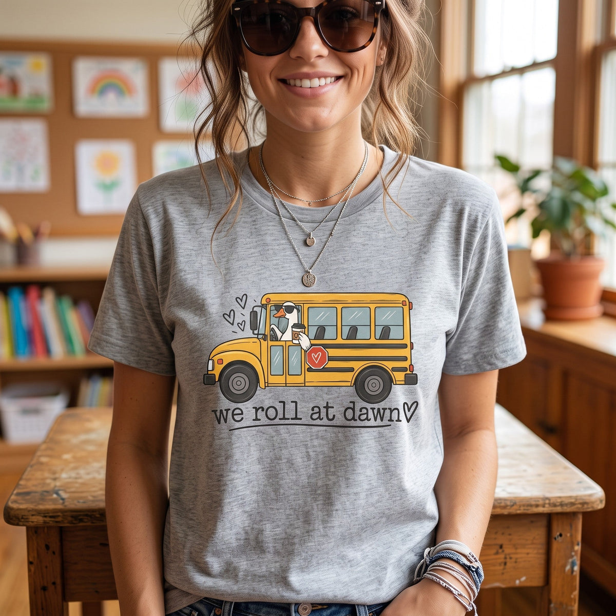 ChalkboardxChaos grey teacher t-shirt featuring a yellow school bus graphic with a coffee-drinking driver