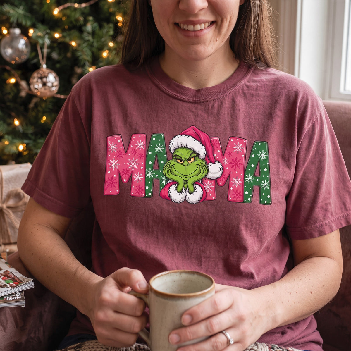 ChalkboardxChaos Grinch Mama Christmas tee in maroon with pink and green snowflake lettering and Grinch graphic.