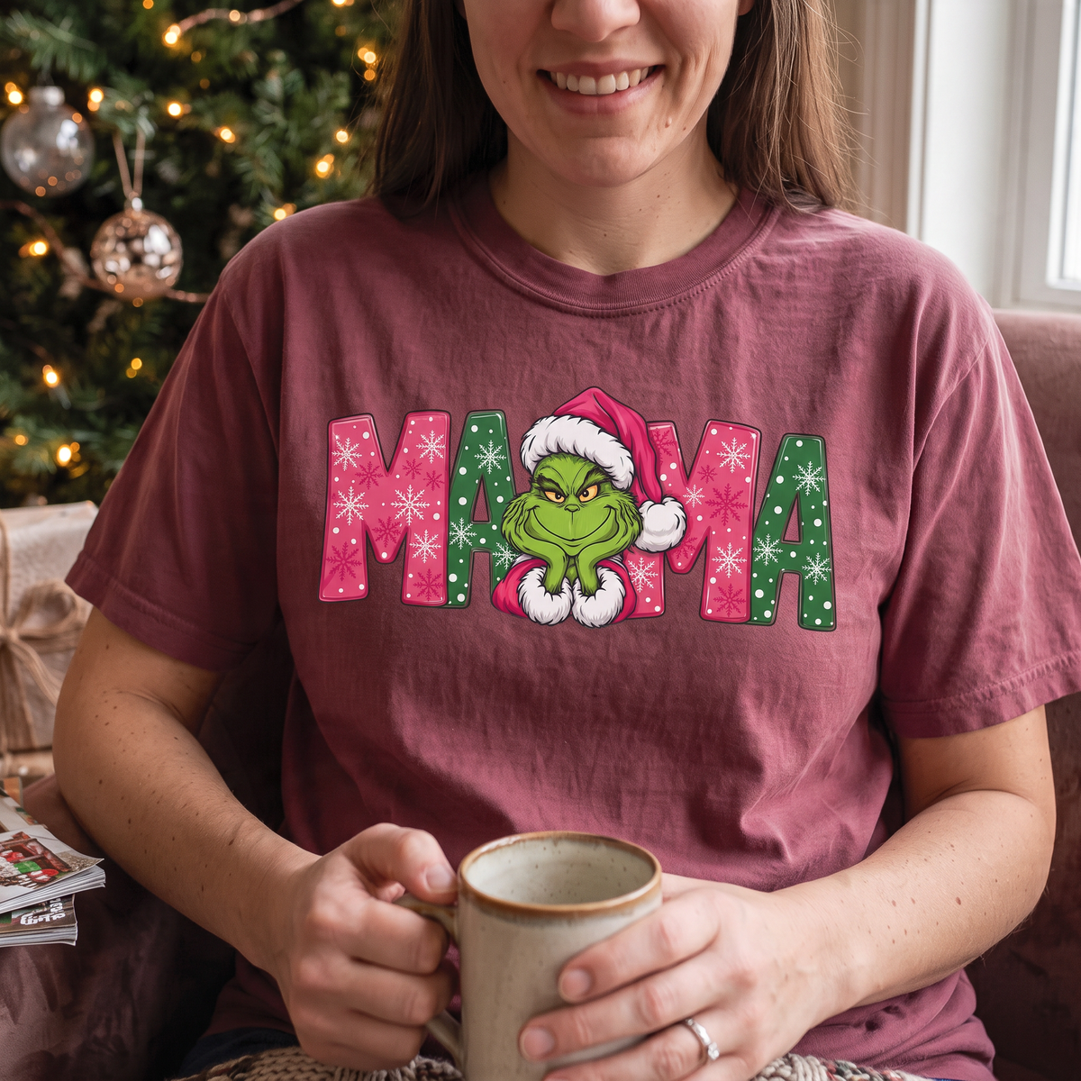 ChalkboardxChaos Grinch Mama Christmas tee in maroon with pink and green snowflake lettering and Grinch graphic.