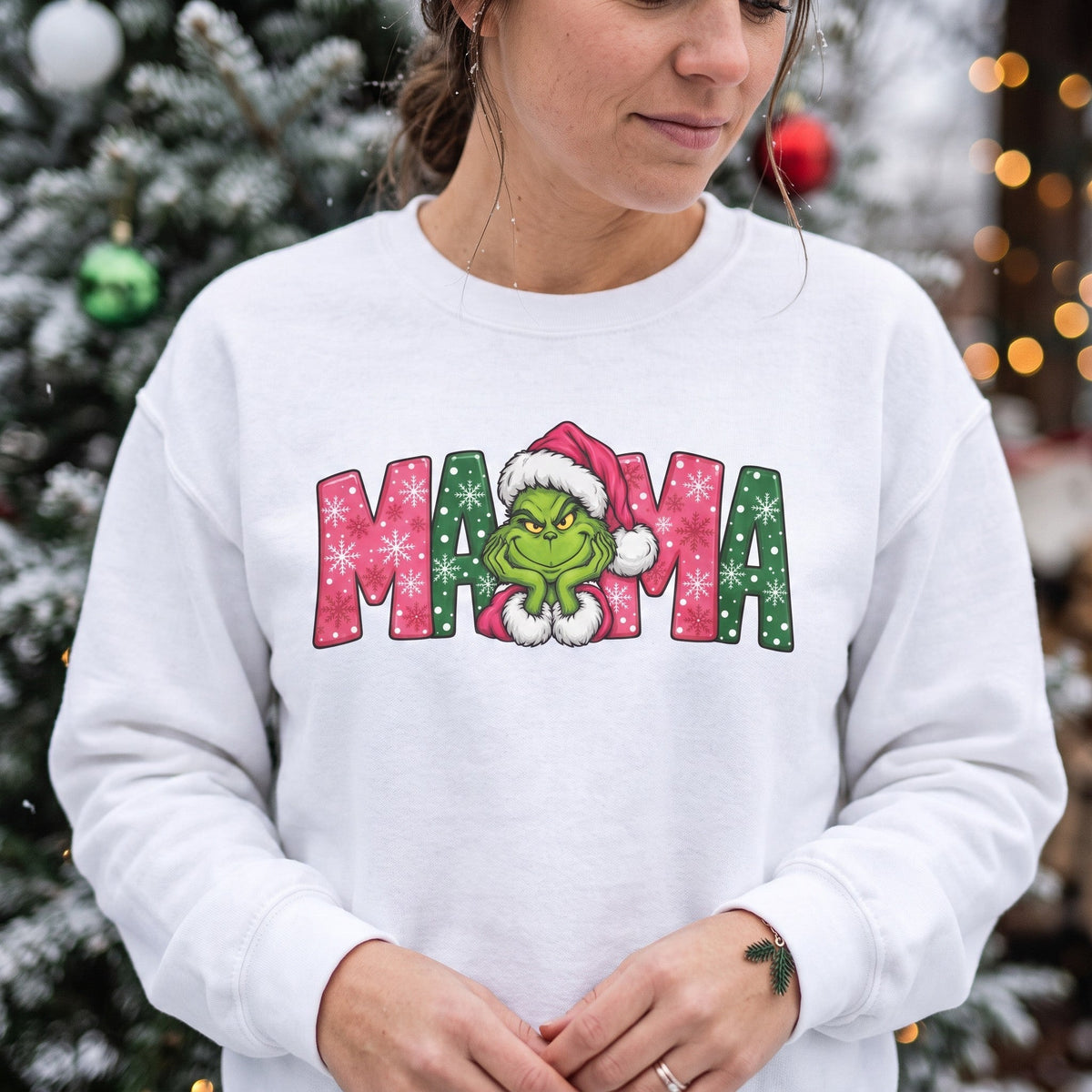 ChalkboardxChaos white sweatshirt featuring a Grinch Mama graphic with pink and green festive snowflake lettering.