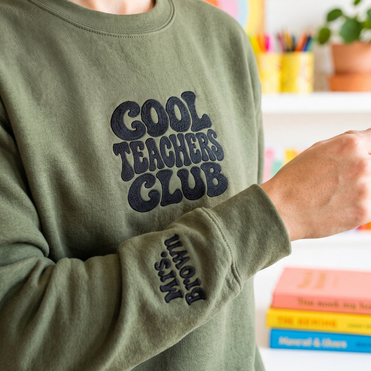 ChalkboardxChaos olive green sweatshirt with black Cool Teachers Club embroidery and personalized name on the wrist