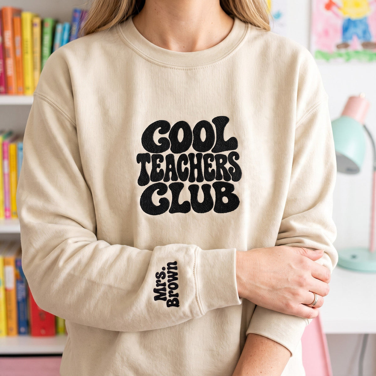 ChalkboardxChaos beige sweatshirt with black retro Cool Teachers Club embroidery and personalized wrist text