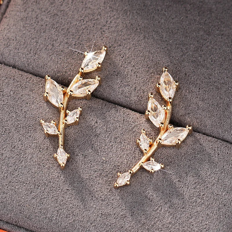 ChalkboardxChaos silver-tone crystal leaf branch earrings with marquise-cut stones on a grey velvet display